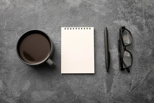 Σημειωματάριο με φλιτζάνι καφέ, γυαλιά ηλίου και στυλό σε σκούρο φόντο — Φωτογραφία Αρχείου