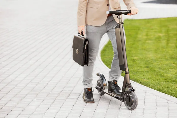 Giovane uomo d'affari con calcio scooter all'aperto — Foto Stock