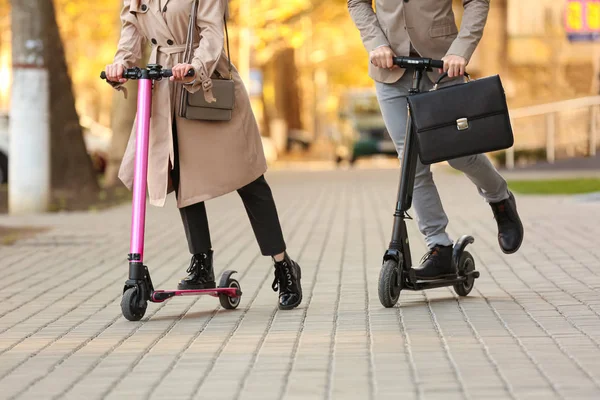 Jovem casal equitação chute scooters ao ar livre — Fotografia de Stock