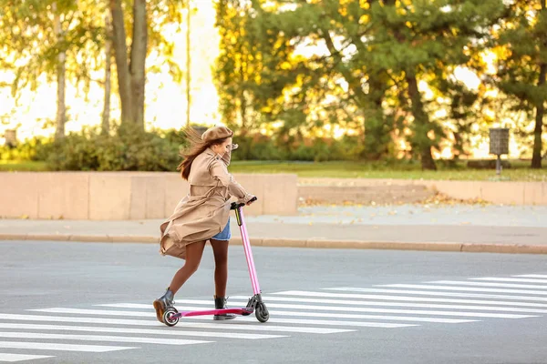 Junge Frau fährt Tretroller im Freien — Stockfoto