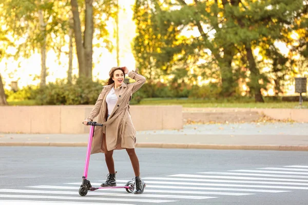 Jeune femme chevauchant un scooter de coup de pied à l'extérieur — Photo