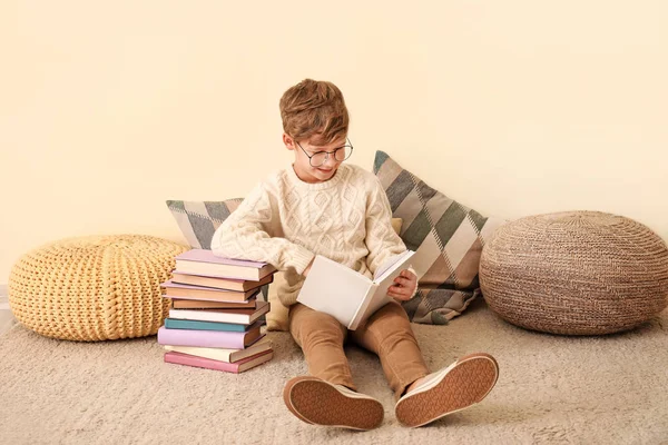 Kleiner Junge liest Bücher in der Nähe der Wand — Stockfoto