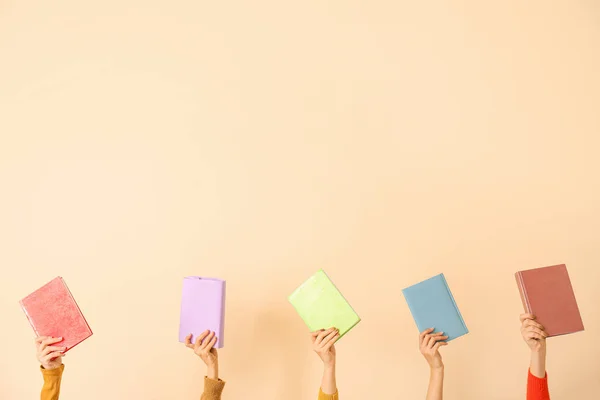 Vrouwelijke handen met boeken over kleur achtergrond — Stockfoto