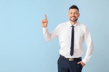 Renk arkaplanı üzerinde işaret parmağı yükseltilmiş bir iş adamı