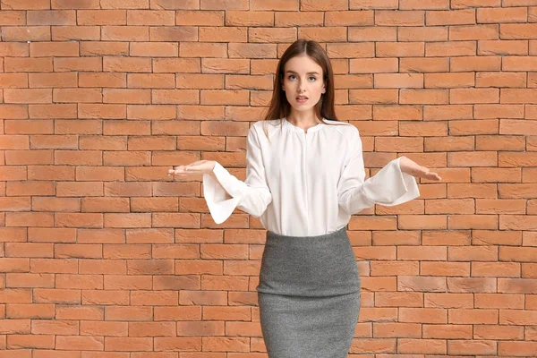 Helpless businesswoman on brick background. Concept of choice — Stock Photo, Image