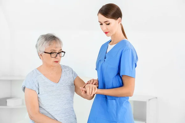 Médecin avec une femme âgée souffrant du syndrome de Parkinson en clinique — Photo