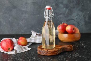 Koyu arkaplanda elma sirkesi şişesi