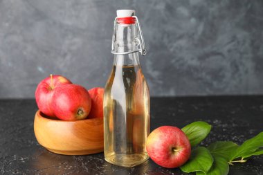 Koyu arkaplanda elma sirkesi şişesi