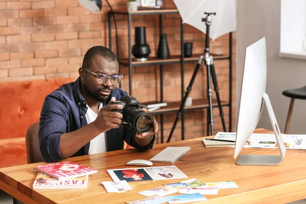 Fotógrafo afroamericano en mesa en estudio — Foto de Stock