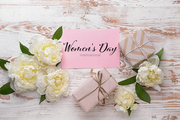 Card for International Women's Day and beautiful flowers with gifts on wooden background — Stockfoto
