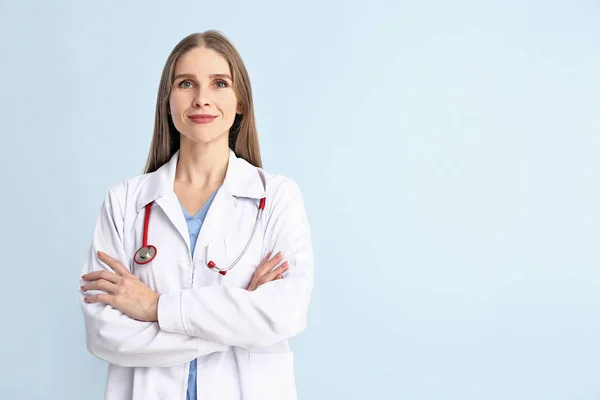 Portrait of female doctor on color background — Stock Photo, Image