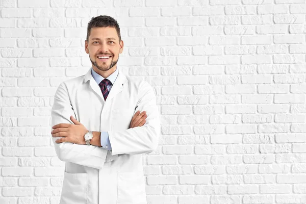 Portrait of male doctor on white brick background — 스톡 사진