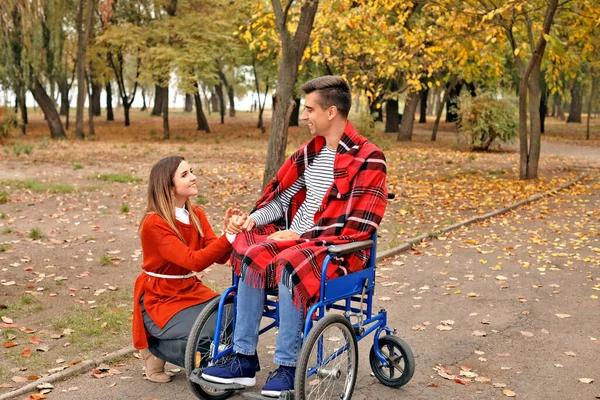 Handicapped mladý muž a jeho žena v podzimním parku — Stock fotografie