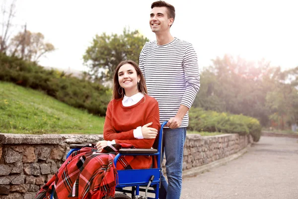 Handicapped young woman and her husband in autumn park — Stock Photo, Image