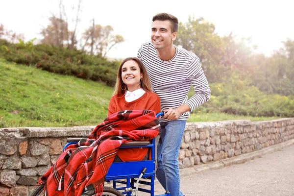 Mujer joven discapacitada y su marido en el parque de otoño — Foto de Stock