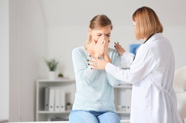 Kadın doktor klinikteki üzgün hastayı sakinleştiriyor.