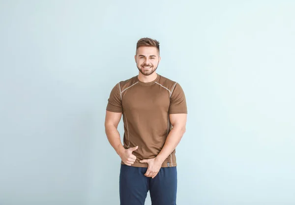 Young man with healthy urogenital system showing thumb-up on light background — 스톡 사진