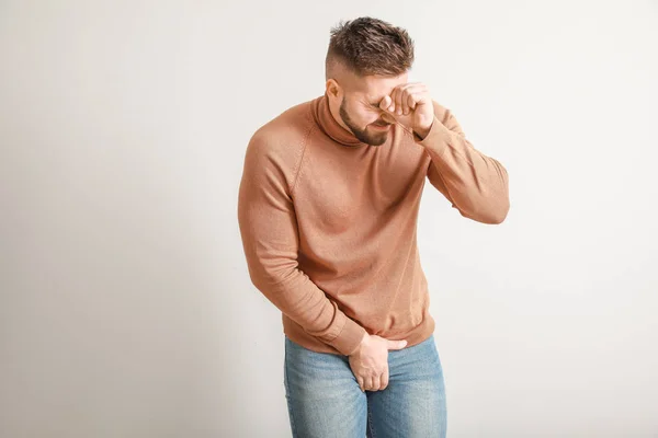 Young man with urologic disease on light background — Stock Photo, Image