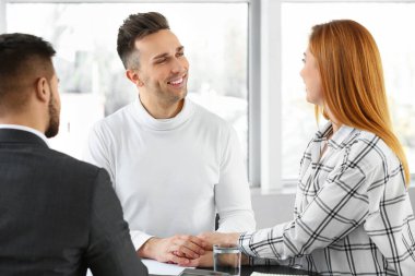 Banka müdürü ofiste müşterilerle çalışıyor.