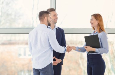 Banka müdürü ve müşterileri ofiste el sıkışıyor