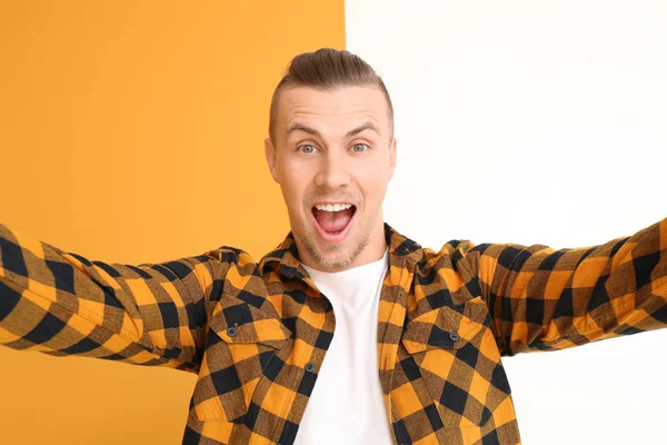 Handsome young man taking selfie on color background — Stock Photo, Image