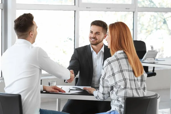 Bank manager and clients shaking hands in office — Stock Photo, Image