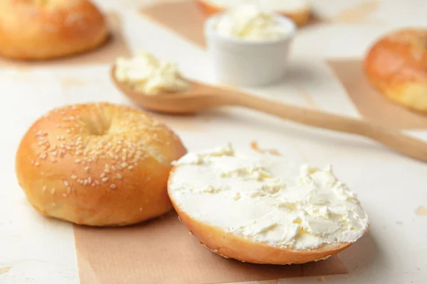Свежая булочка с вкусным сливочным сыром на белом фоне — стоковое фото