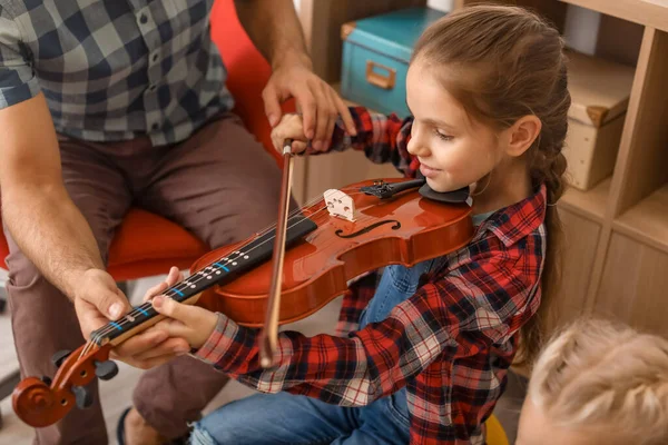 Teacher giving music lessons at school