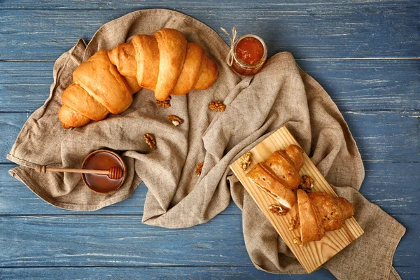 Lekkere zoete croissants met jam op houten tafel — Stockfoto