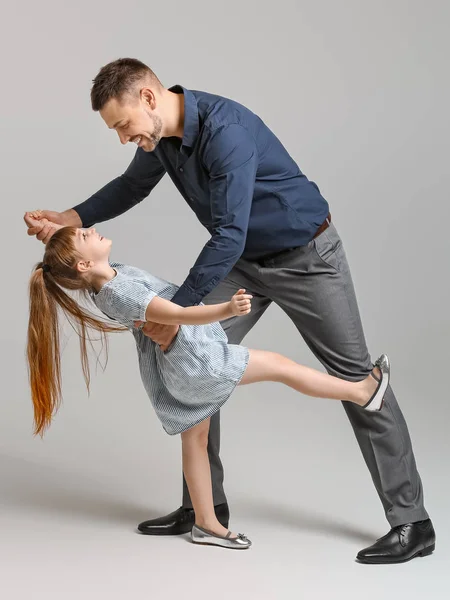 Padre y su hijita bailando sobre fondo gris — Foto de Stock