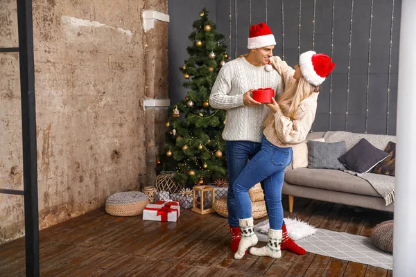 Casal feliz com presente de Natal em casa — Fotografia de Stock