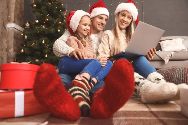 Happy family with laptop on Christmas eve at home — Stockfoto