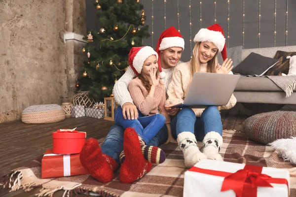 Happy family with laptop on Christmas eve at home — Stockfoto