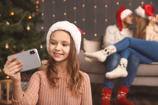 Little girl taking selfie on Christmas eve at home — Stockfoto