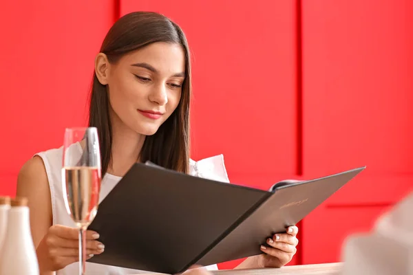 Jovem com menu sentado no restaurante — Fotografia de Stock