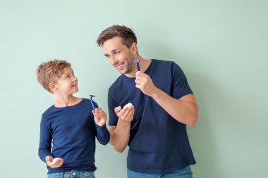 Baba ve küçük oğlu gri arka plan aleyhine tıraş