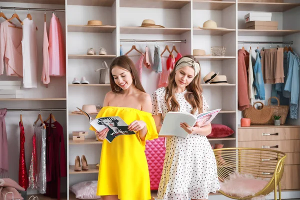 Hermosas mujeres jóvenes leyendo revistas de moda en el vestidor —  Fotos de Stock