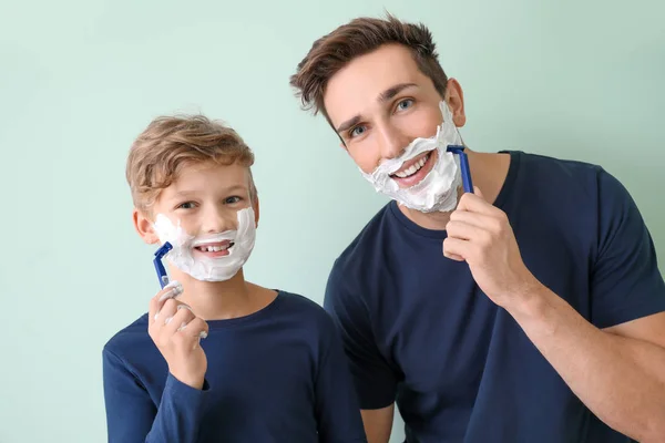 Father and his little son shaving against grey background — Stock Photo, Image