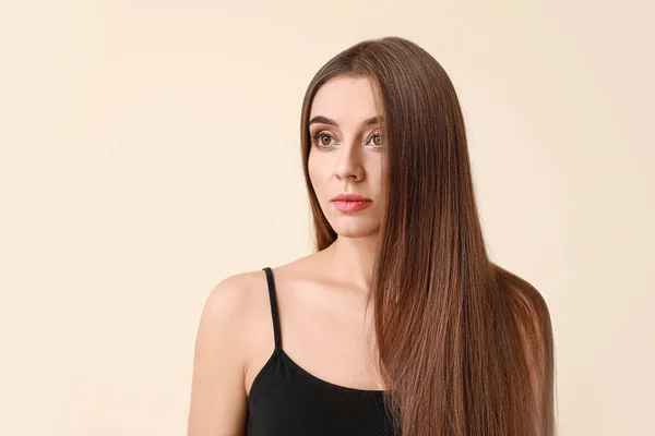 Vacker kvinna med frisk långt hår på ljus bakgrund — Stockfoto