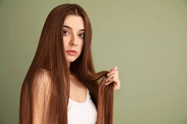 Vacker kvinna med frisk långt hår på färg bakgrund — Stockfoto