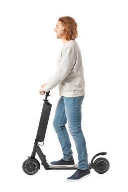 Young man with kick scooter on white background