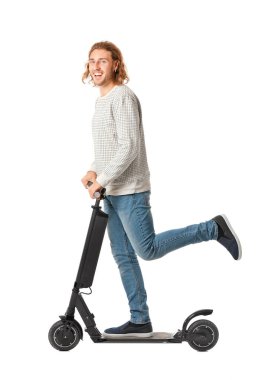 Young man with kick scooter on white background