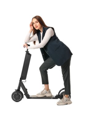 Young woman with kick scooter on white background