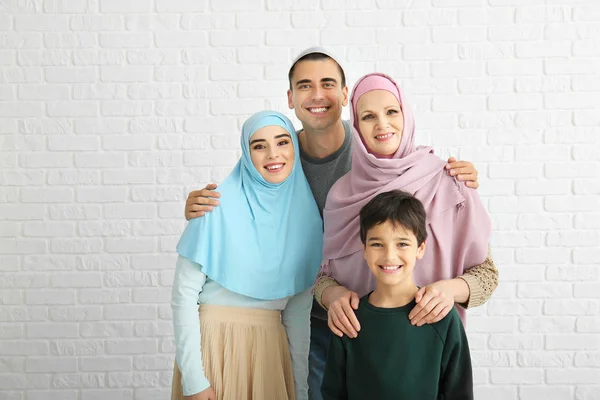 Portrait of Muslim family on white brick background — Stock Photo, Image