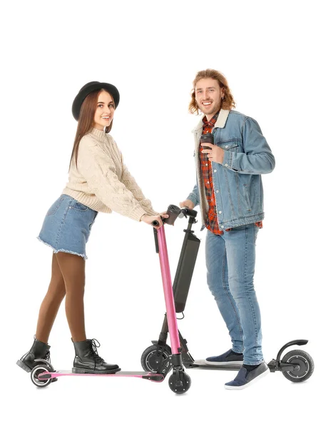 Jovem casal com scooters pontapé e xícaras de café no fundo branco — Fotografia de Stock