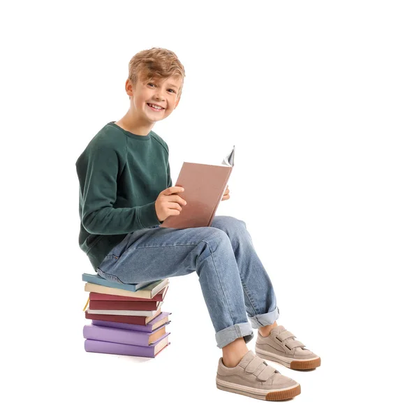Kleiner Junge liest Buch auf weißem Hintergrund — Stockfoto