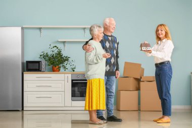 Bayan emlakçı içeride yaşlı bir çiftle çalışıyor.