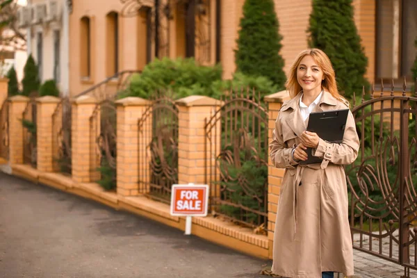 Female real estate agent near house for sale outdoors — Stock Photo, Image