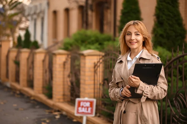 Female real estate agent near house for sale outdoors — Stock Photo, Image