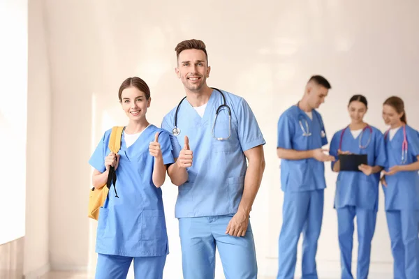 Medical students showing thumb-up gesture in hall of clinic — Stock Photo, Image